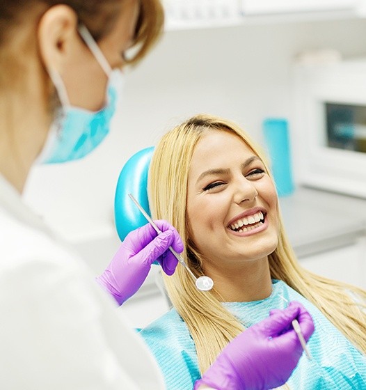 Woman in dental chair laughing