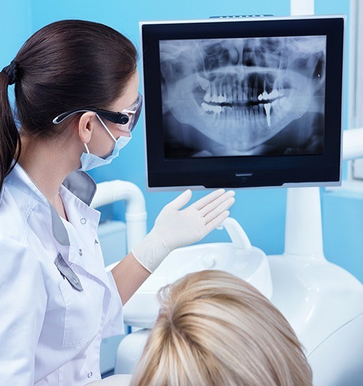 Dentist and patient looking at digital x-rays