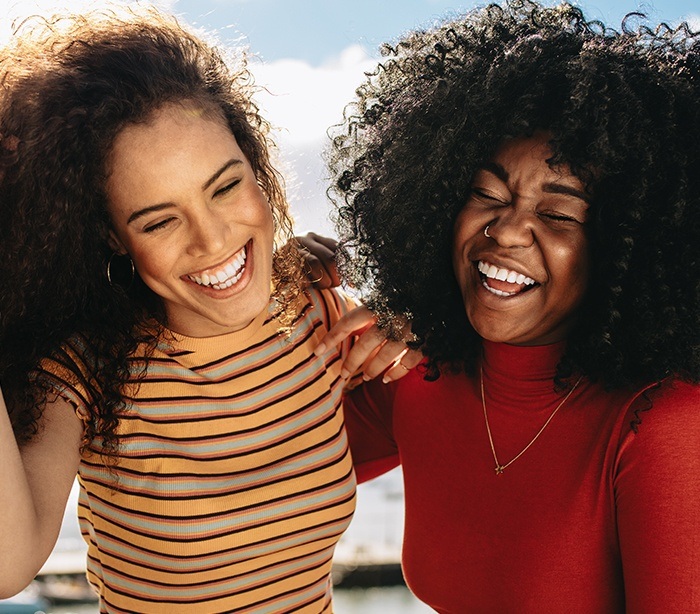 Two women smiling after crown lengthening treatment