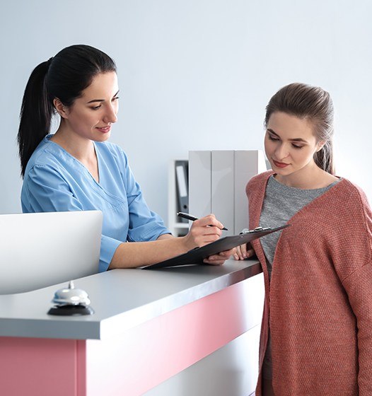 Dental team member and patient discussing the cost of treating dental emergencies