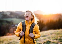 a person hiking with an orange jacket and a backpack