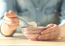 woman eating yogurt after getting dental implants in Sunnyvale