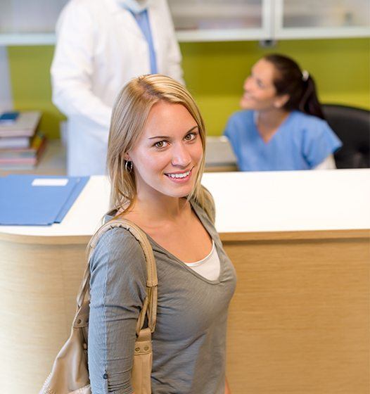 Woman at dental office reception desk