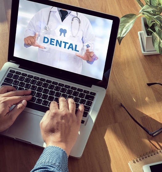 Patient looking at dental insurance on laptop computer