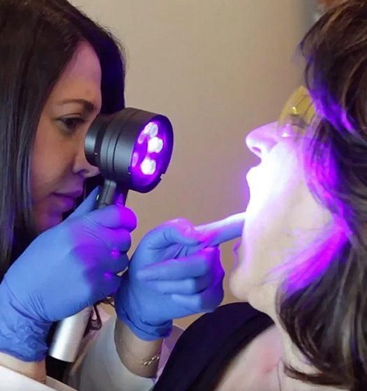 Dentist performing oral cancer screening