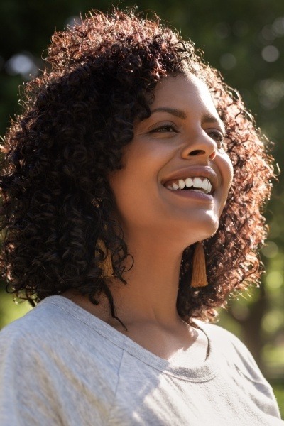 Woman sharing flawless smile after emergency dentistry treatment