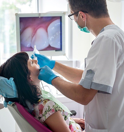Dentist using intraoral camera to capture images of a smile