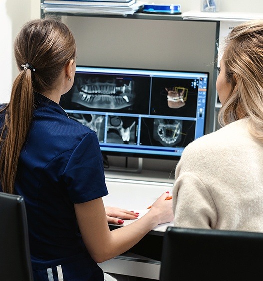 Dental team members looking at digital x-rays